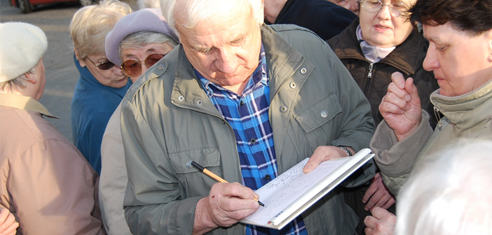 na zdjęciu mieszkańcy podpisują petycję